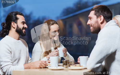 Image of happy friends meeting and drinking tea or coffee