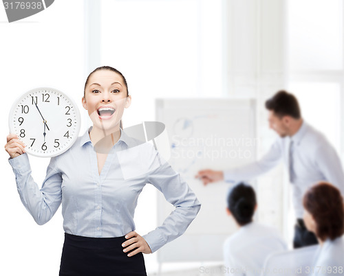 Image of attractive businesswoman with wall clock