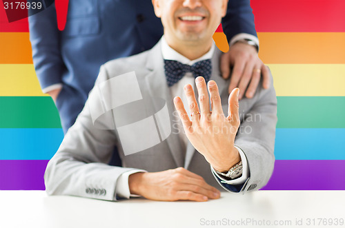 Image of close up of male gay couple with wedding rings on