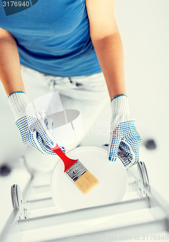 Image of woman with paintbrush and paint pot