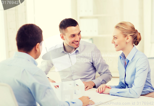 Image of couple looking at model of their house at office