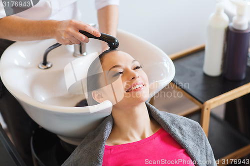 Image of happy young woman at hair salon