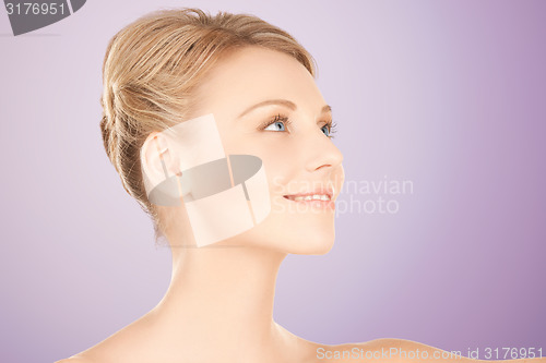 Image of beautiful young woman face over violet background