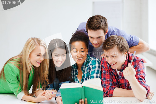 Image of students reading book at school