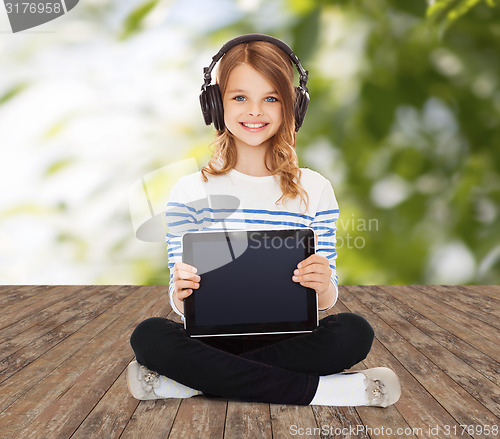 Image of happy girl with headphones showing tablet pc