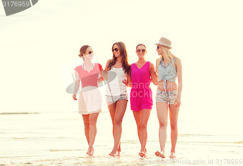 Image of group of smiling women in sunglasses on beach
