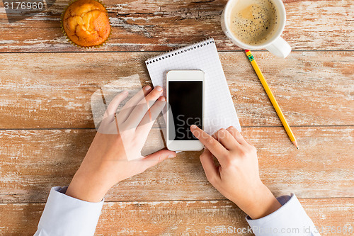 Image of close up of hands with smartphone and coffee cup