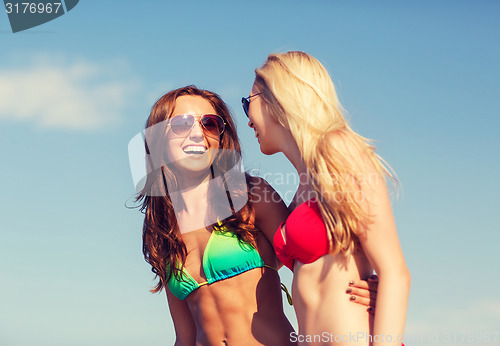 Image of two laughing young women on beach