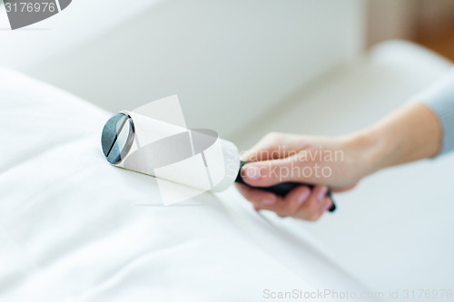 Image of close up of woman hand with sticky roller cleaning