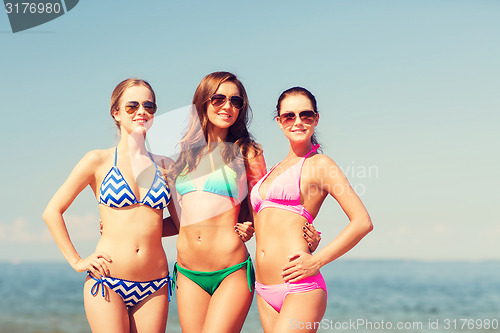 Image of group of smiling young women on beach