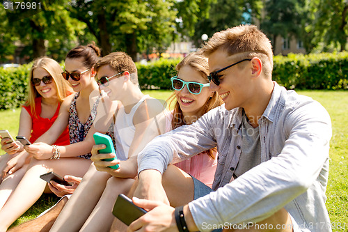 Image of smiling friends with smartphone making selfie