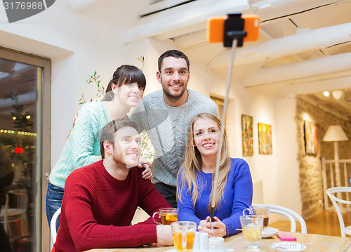 Image of group of friends taking selfie with smartphone