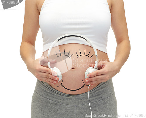 Image of close up of pregnant woman and headphones on tummy