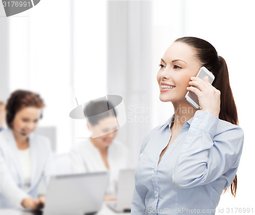 Image of young smiling businesswoman with smartphone