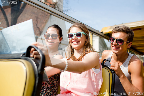 Image of group of smiling friends traveling by tour bus