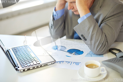 Image of close up of stressed old man with laptop in office