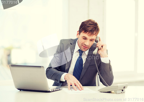 Image of businessman with laptop computer and phone