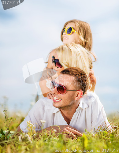 Image of happy family with blue sky and green grass