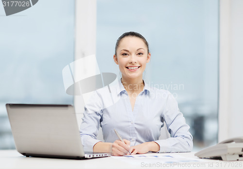 Image of businesswoman with phone, laptop and files