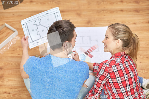 Image of happy couple with blueprint and color samples