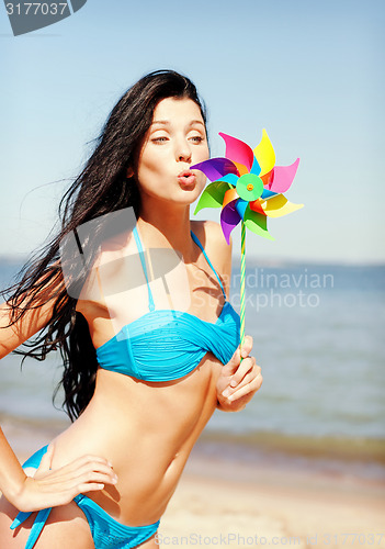 Image of girl with windmill toy on the beach