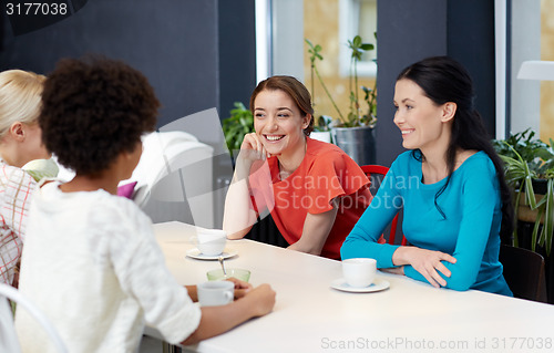 Image of happy young women drinking tea or coffee at cafe