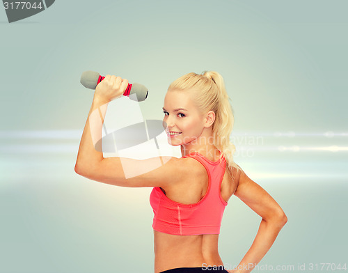 Image of young sporty woman with light dumbbell