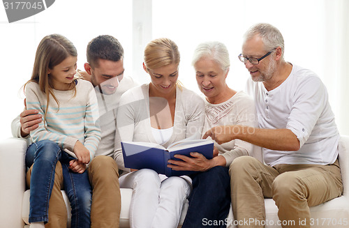 Image of happy family with book or photo album at home