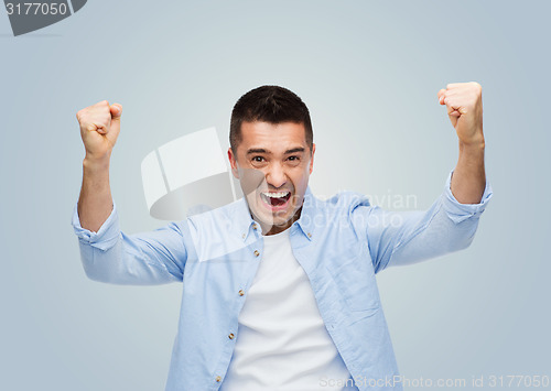 Image of happy laughing man with raised hands