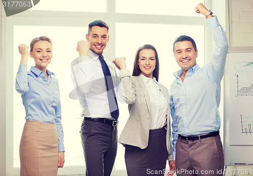 Image of business team celebrating victory in office