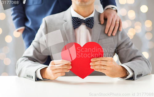 Image of close up of male gay couple with red heart
