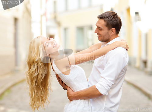 Image of smiling couple dancing in the city