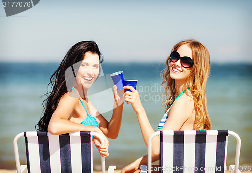 Image of girls with drinks on the beach chairs