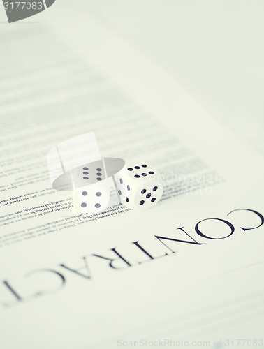 Image of contract paper with gambling dices