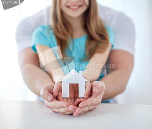 Image of close up of man and girl hands with paper house