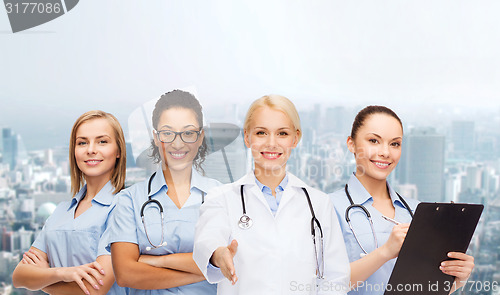 Image of smiling female doctor and nurses with stethoscope