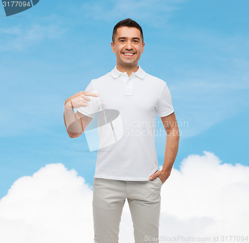 Image of smiling man in t-shirt pointing fingers on himself