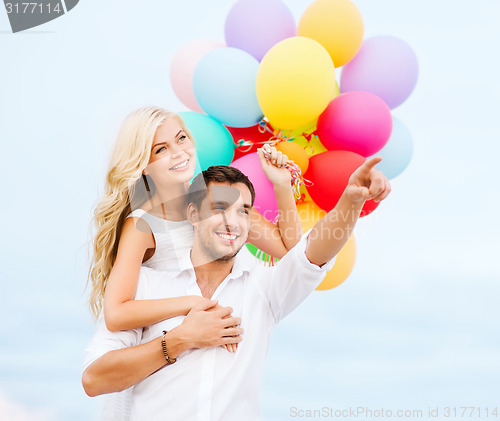 Image of couple with colorful balloons at sea side