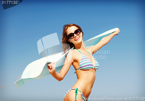 Image of girl in bikini and shades on the beach