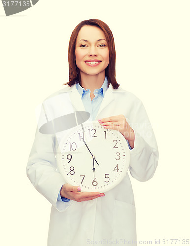 Image of smiling female doctor with wall clock