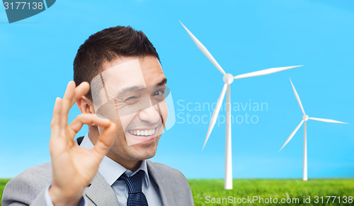 Image of happy businessman in suit showing ok hand sign