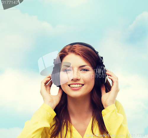 Image of smiling young girl in headphones at home