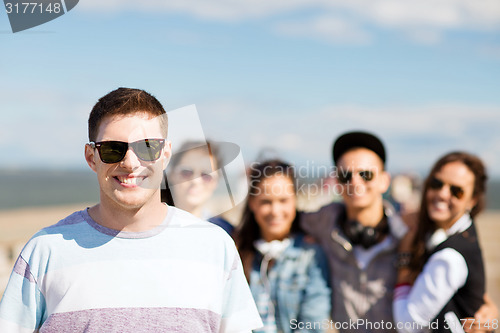 Image of teenager in shades outside with friends