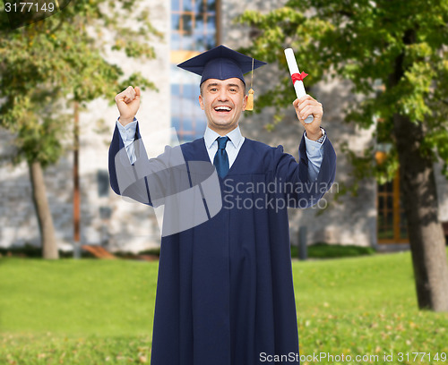 Image of smiling adult student in mortarboard with diploma