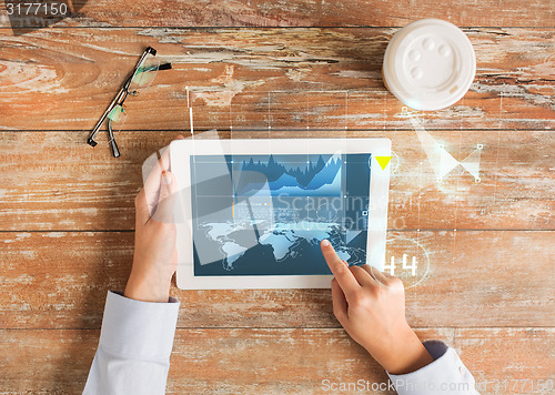 Image of close up of hands with tablet pc and virtual graph
