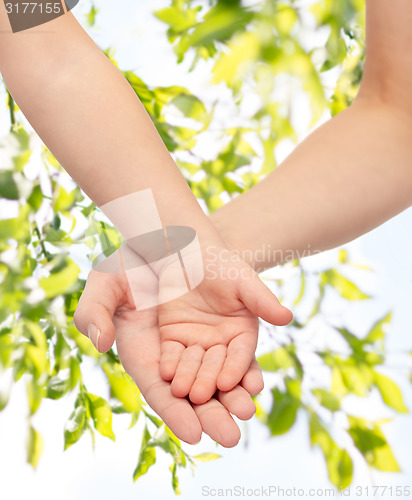 Image of close up of woman and little child hands together