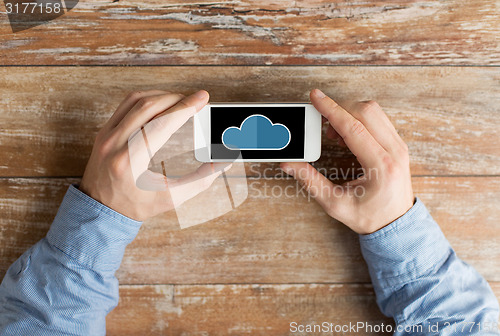 Image of close up of male hands with cloud on smartphone