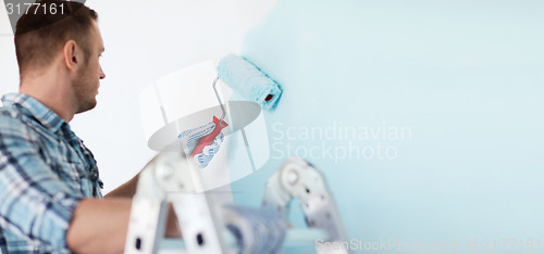 Image of close up of male in gloves holding painting roller