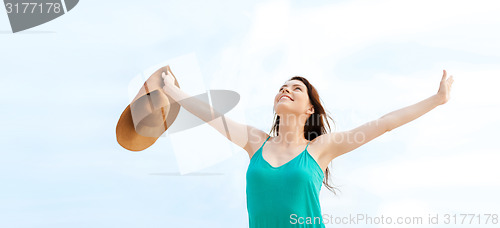 Image of girl with hands up on the beach