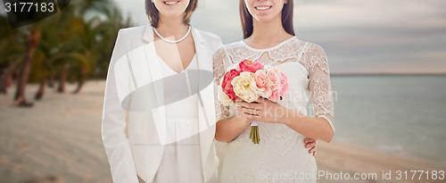 Image of close up of happy lesbian couple with flowers